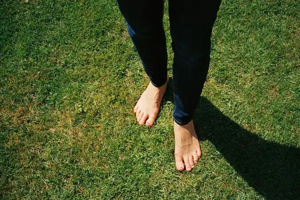 person standing barefoot on green grass field